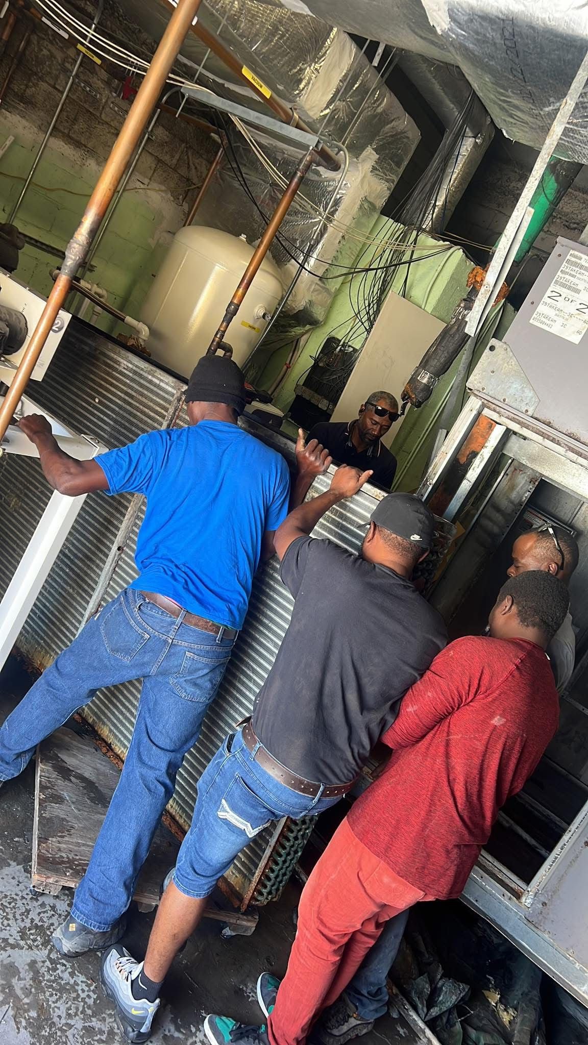Four-man team servicing large commercial AC system